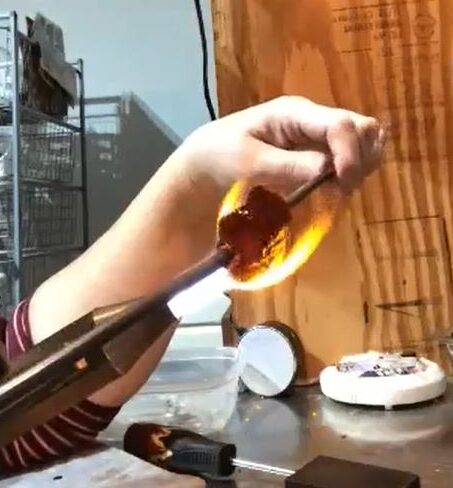 Ann evenly heating a large picture-murrini gather at her torch