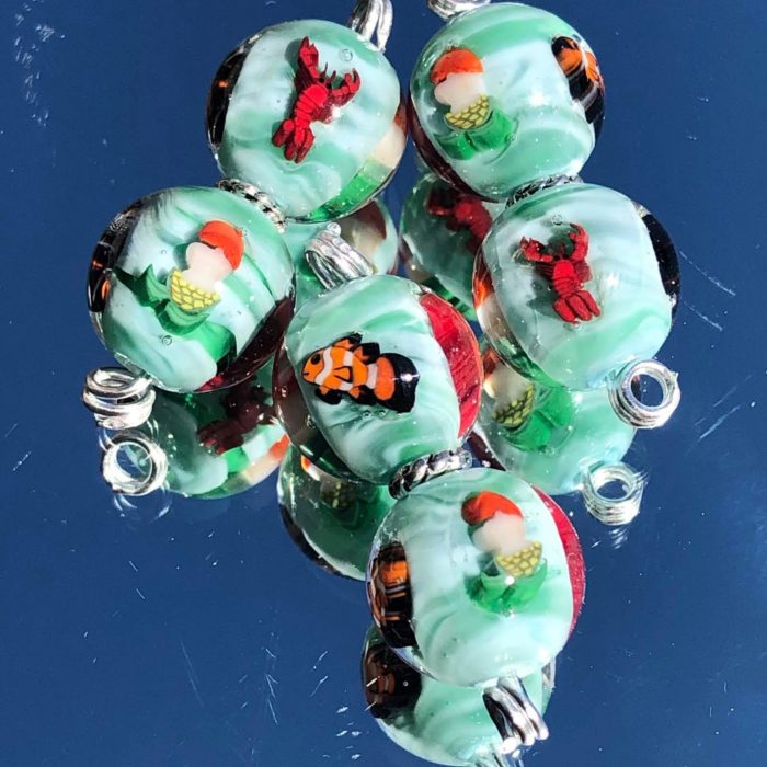 A cluster of Ann’s sea-themed lampwork beads with tiny pictures set inside